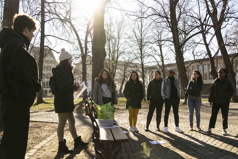 Gruppe hört Stadtführerin zu